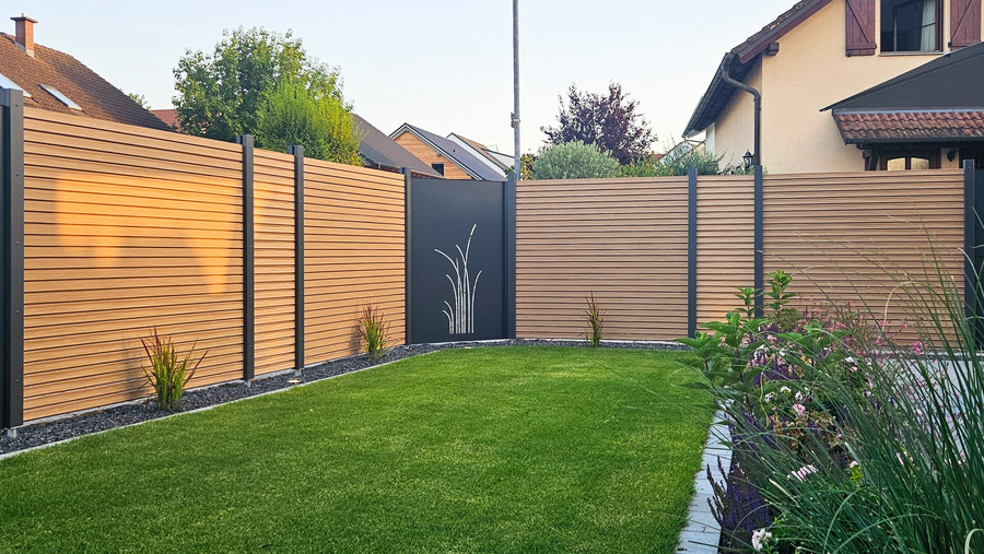 Moderner Sichtschutzzaun aus Aluminium mit Rhombusprofilen in Lärchenoptik im Garten
