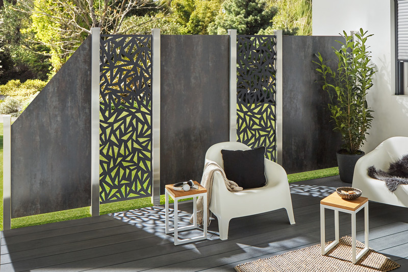 SYSTEM Keramik Sichtschutz mit Designfüllungen in Steinoptik Moderner SYSTEM Keramik Sichtschutz mit großformatigen Keramikplatten in Steinoptik und dekorativen Design-Einsätzen für Garten und Terrasse