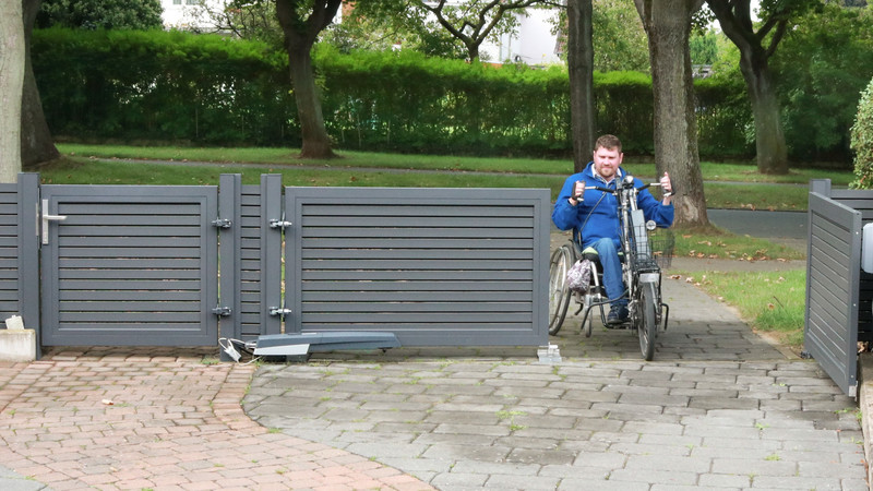 Moderne Toranlage aus Aluminium mit Einzeltor und elektrisch betriebenem Doppeltor für die Grundstückszufahrt